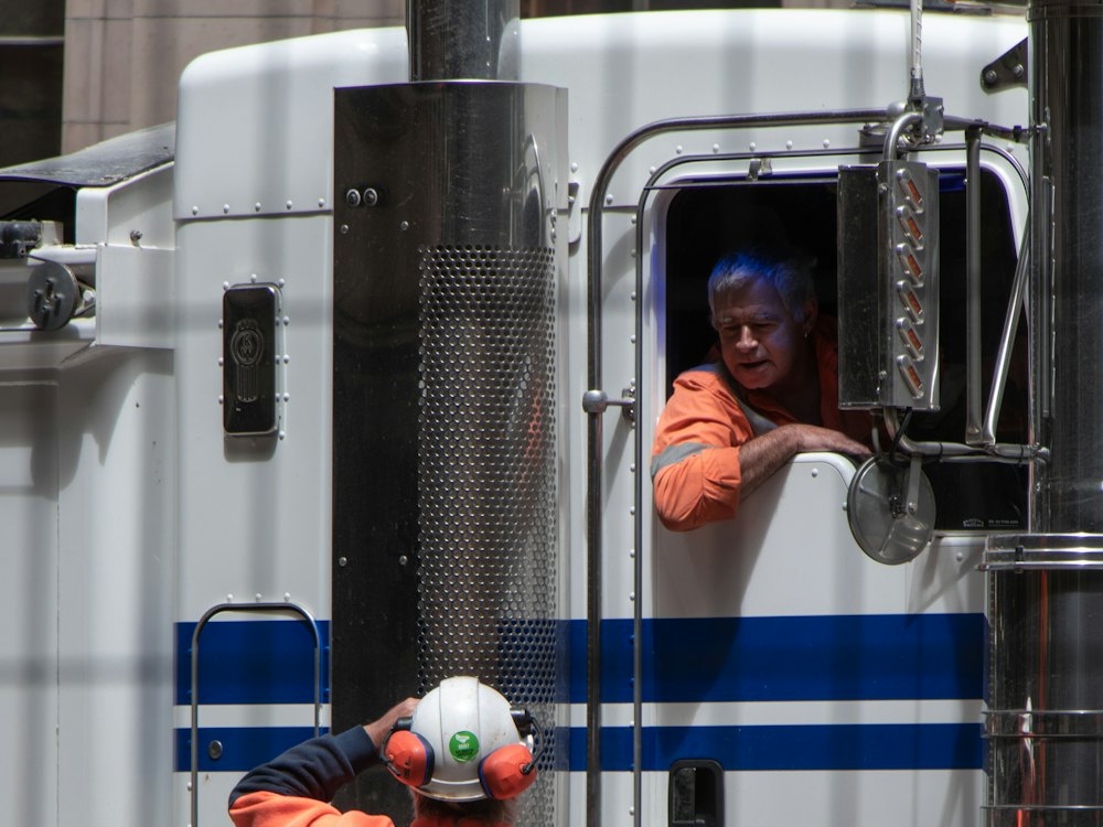 Freight truck with a worker standing beside it (stock photo)